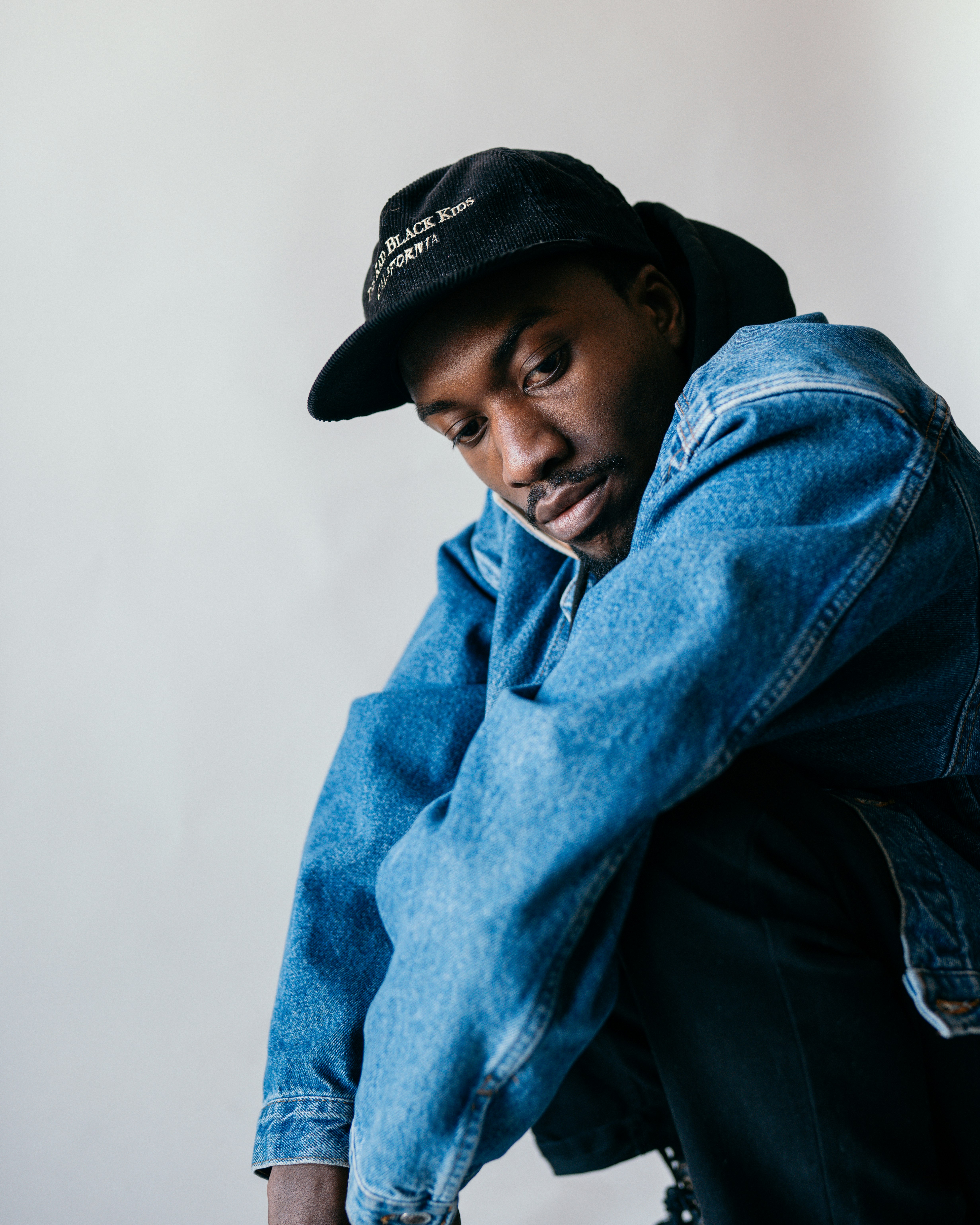 man in blue denim jacket and black hat